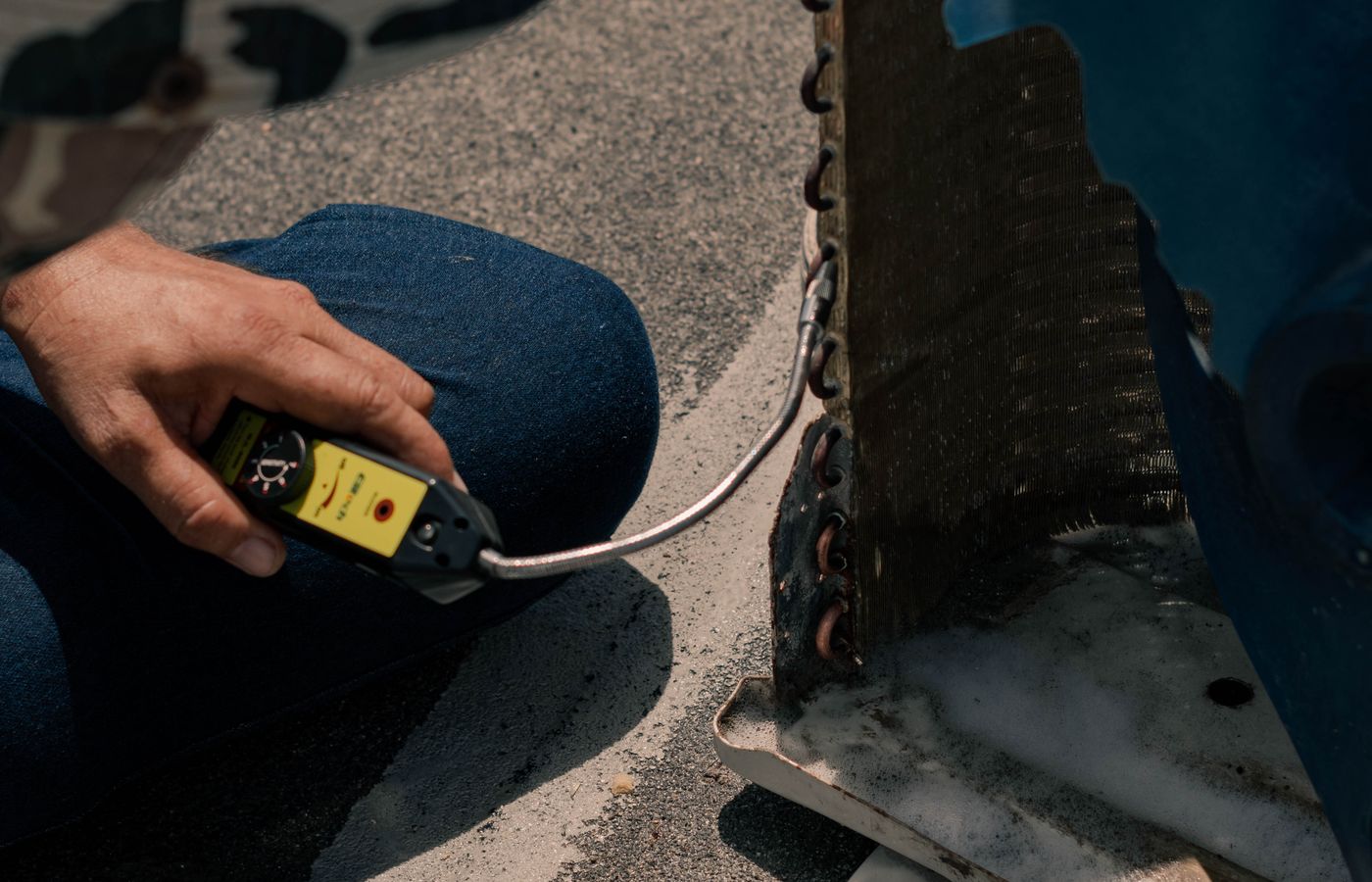 HVAC technician inspecting an outdoor air conditioning unit