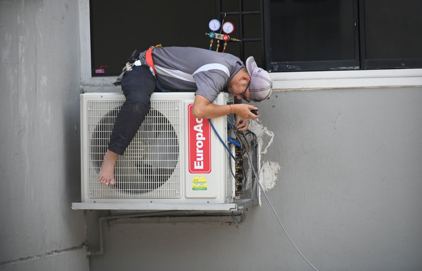 HVAC technician inspecting an outdoor air conditioning unit